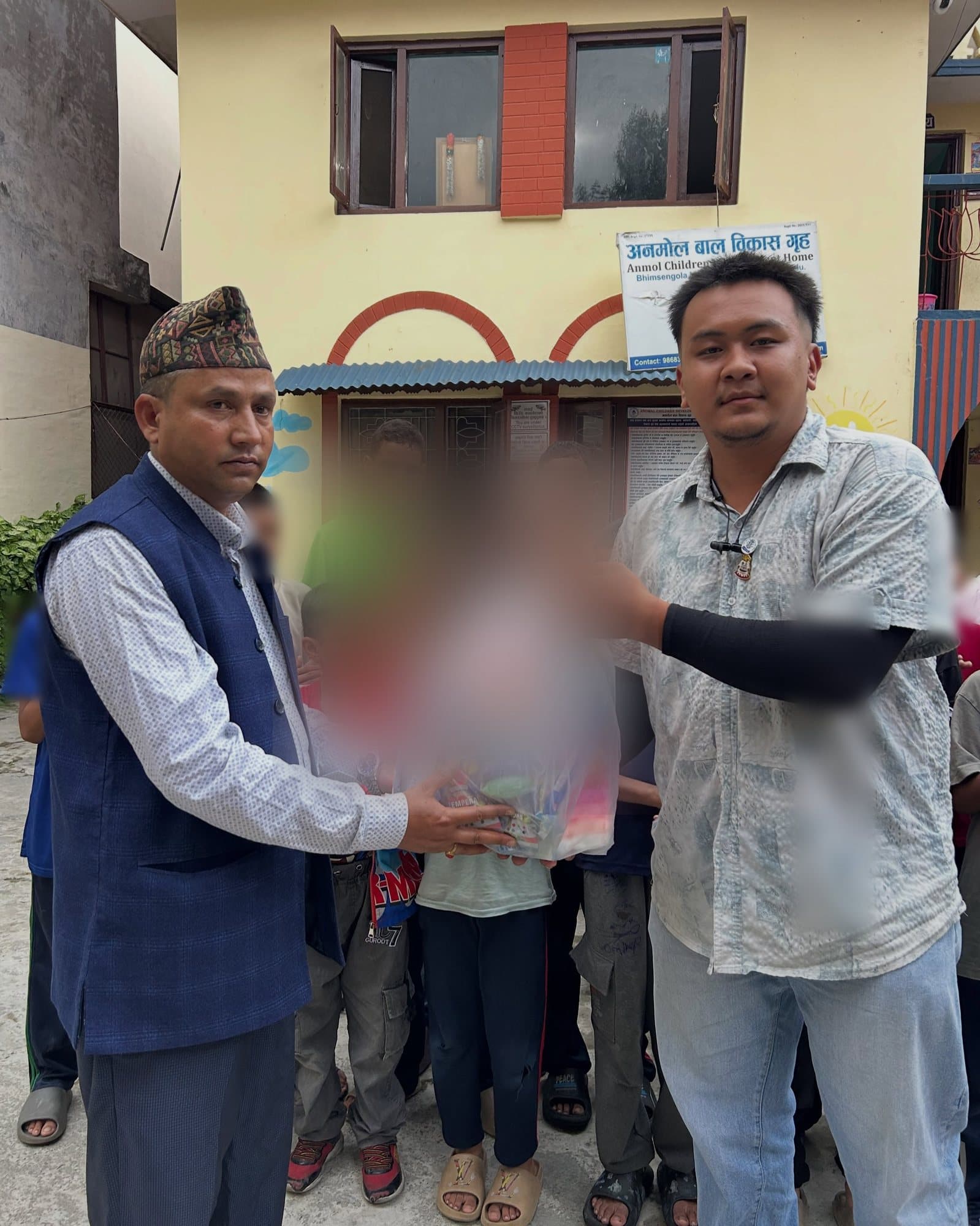 A Leo member and a warden hold a bag of toys for a hand-over at Anmol Children Development Home.